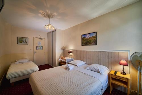 a hotel room with two beds in a room at La Caravelle in Riom
