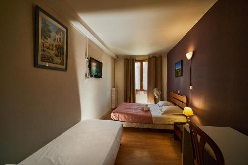 a small room with two beds and a window at La Caravelle in Riom