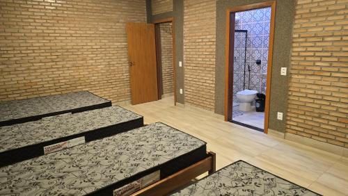 una stanza con tre letti e una porta per un bagno di Chácara Recanto dos Pássaros 04 a Olímpia