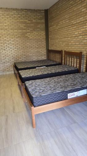 two beds sitting in a room with a wall at Chácara Recanto dos Pássaros 04 in Olímpia