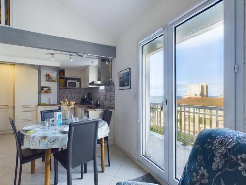 une cuisine et une salle à manger avec une table et une fenêtre dans l'établissement Appartement coquet avec vue sur mer, à Saint-Hilaire-de-Riez