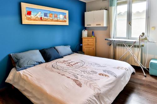 a bedroom with a bed with a blue wall at La Maison du Mazet in Maillane