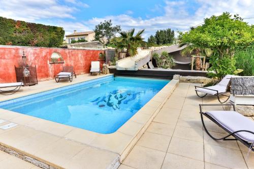 a swimming pool in a yard with chairs and a patio at La Maison du Mazet in Maillane