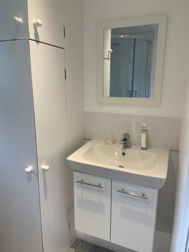 a white bathroom with a sink and a mirror at The Batch in Thorverton