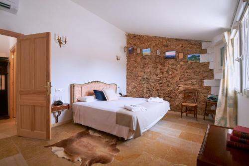 a bedroom with a bed and a stone wall at Castell Granadella in L'Ampolla