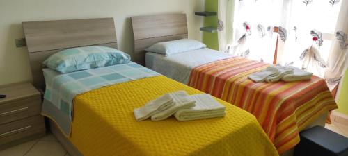 two beds in a bedroom with towels on them at APPARTAMENTI RIMINI NEL CUORE in Rimini
