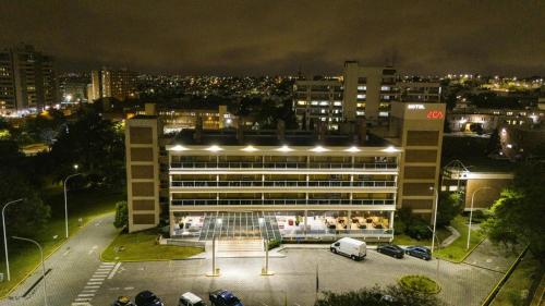 a large building with cars parked in a parking lot at night at Dr Cesar Carman in Cordoba