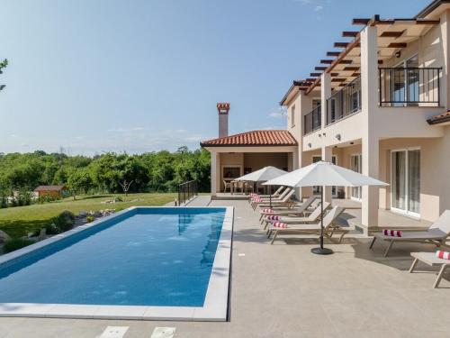 una piscina con sedie e ombrelloni accanto a un edificio di Casa Olé - City Villa Labin a Labin