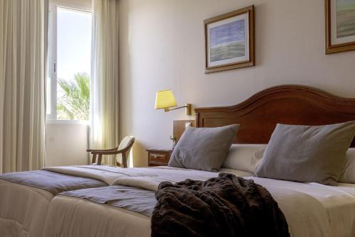 a hotel room with two beds and a window at Hotel Restaurante Emilio in Hellín