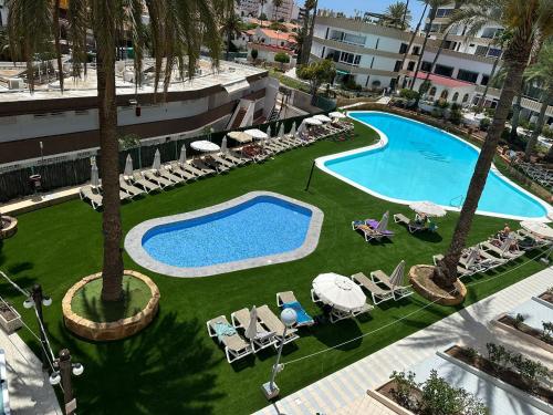 an overhead view of a swimming pool with chaises and palm trees at Il Ducale a Playa del Inglés in Playa del Ingles