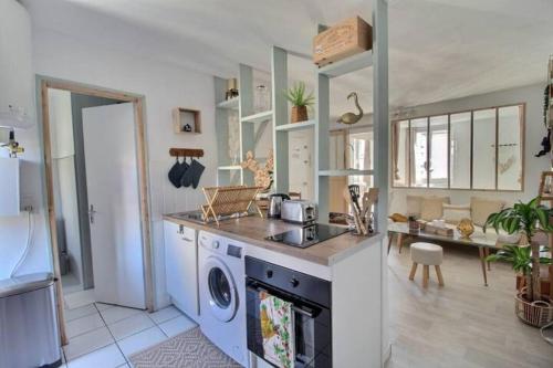 - une cuisine équipée d'un lave-linge, d'un évier et d'une cuisinière dans l'établissement Le Savana - Rénové & Centre-ville, à Bourges