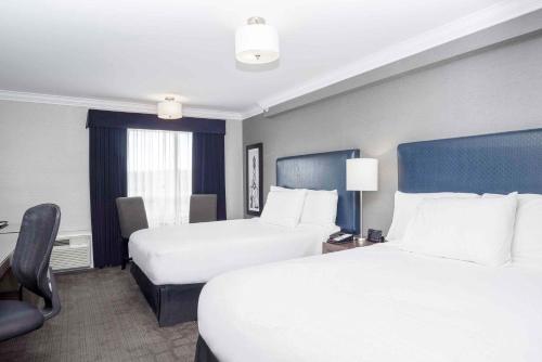 a hotel room with two beds and a window at Sandman Signature Prince George Hotel in Prince George