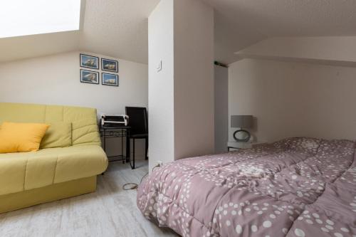 une chambre avec un lit et un canapé dans l'établissement Appartement coquet avec vue sur mer, à Saint-Hilaire-de-Riez