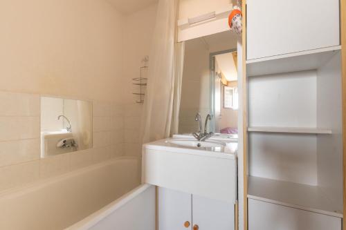 La salle de bains est pourvue d'une baignoire, d'un lavabo et d'une baignoire. dans l'établissement Appartement coquet avec vue sur mer, à Saint-Hilaire-de-Riez