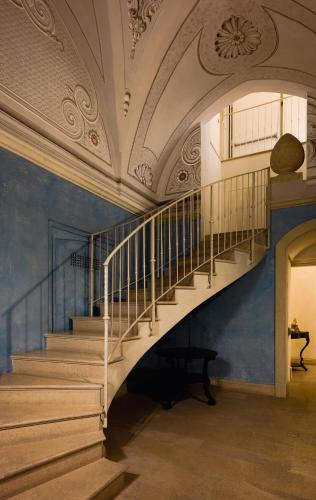 a staircase in a building with a blue wall at Palazzo Gattini Luxury Hotel - VRetreats in Matera