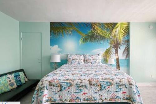a bedroom with a bed with a palm tree mural at Stylish Studio Ocean View in Daytona Beach
