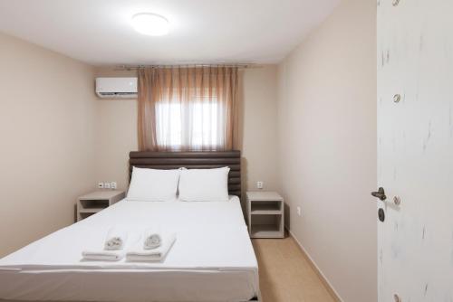 a bedroom with a white bed and a window at Roula's Residence in Flogita