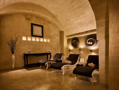 a living room with chairs and a table and a piano at Palazzo Gattini Luxury Hotel - VRetreats in Matera