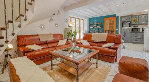 un salon avec des meubles en cuir et une table dans l'établissement Les farinettes, à Arrelles
