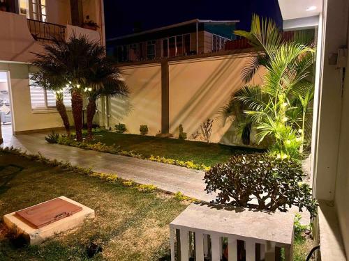 a house with a courtyard with palm trees and a building at Cozy y Quiet House with Private Garden in Cochabamba