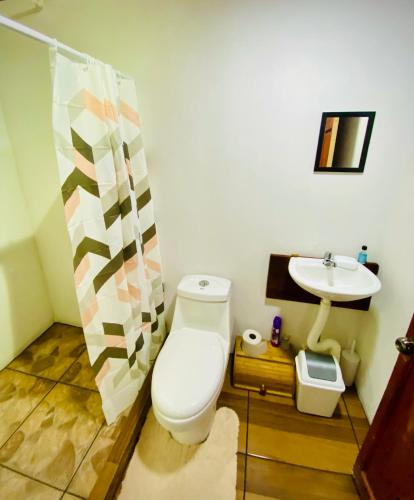 a bathroom with a toilet and a sink at Nomads Family Rooms, Fortuna Town in Fortuna