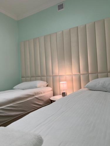 a bedroom with two beds and a lamp on a table at Hostel Kapsułowy in Przemyśl
