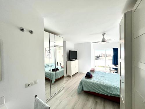 Camera bianca con letto e specchio di Apartamento Luminoso Marbella a Marbella