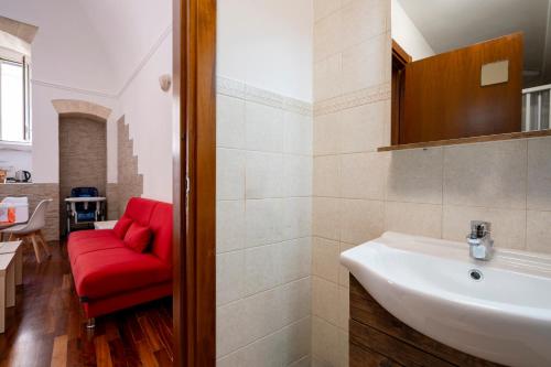 a bathroom with a red couch and a sink at Principe Michelangelo in Bari