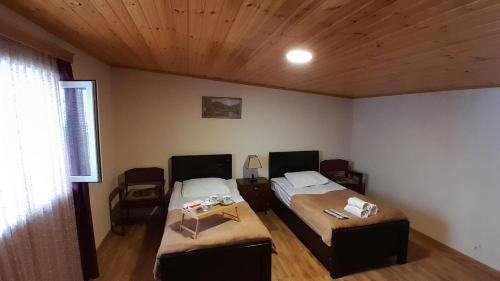 Un dormitorio con dos camas y techo de madera. en Relax in the mountains - kazbegi, en Arsha