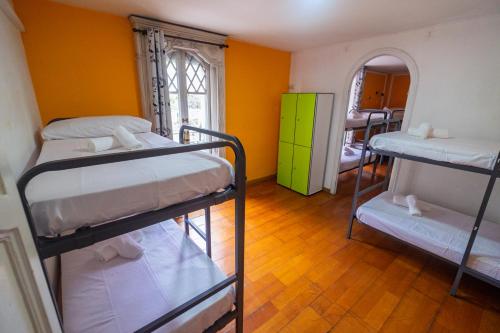 Habitación con 3 literas y pared amarilla. en Diagonal House Hostel, en Barcelona