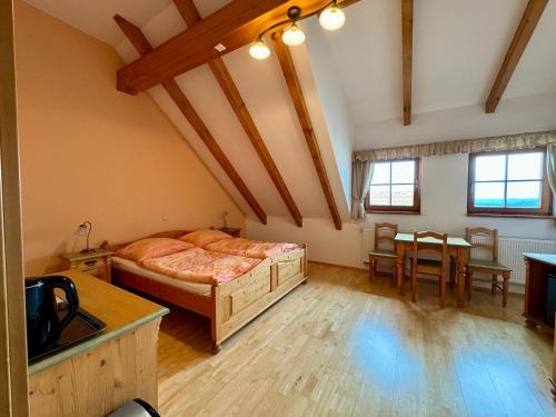 a bedroom with a bed and a table in it at Hotelový a jezdecký areál Dvůr Krutěnice in Krutěnice