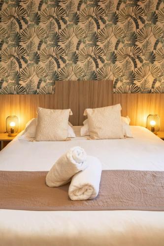 a bed with a stuffed teddy bear sitting on it at Hotel du Levant in Castellane