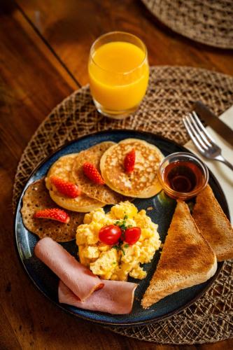 a plate of breakfast food with eggs ham and toast at Hotel du Levant in Castellane