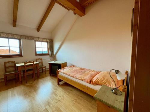 a bedroom with a bed and a table in it at Hotelový a jezdecký areál Dvůr Krutěnice in Krutěnice
