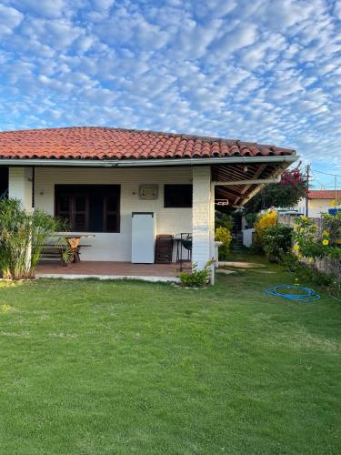 a small white house with a red roof at Casa Vila lagoinha in Lagoinha