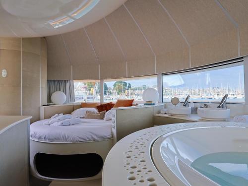 a bathroom with a tub and a bed and a bath tub at ANTHENEA Trebeurden in Trébeurden