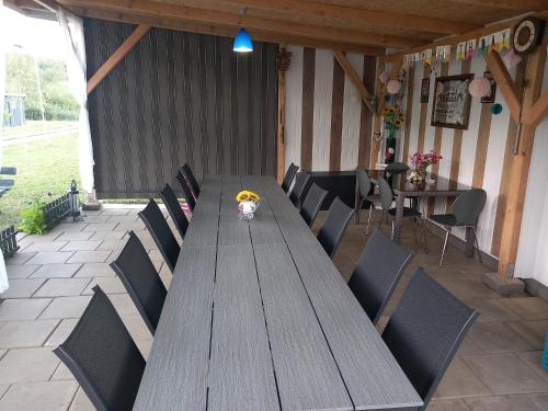 a long wooden table and chairs in a patio at Lacurile IRION in Hoghilag