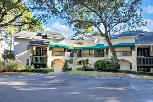a large white building with trees in front of it at Lakeside 312 at Bluewater Bay Resort in Niceville