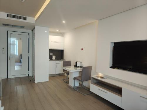 a living room with a flat screen tv and a desk at Central Point Privilege Apartments in Sarajevo