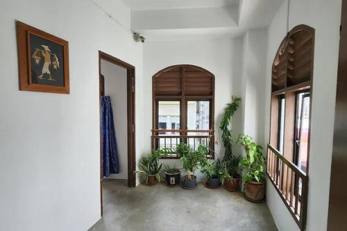 a hallway with potted plants and a window at Vintage Inn Jonker Walk Melaka in Melaka