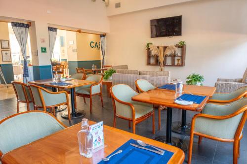 a dining room with wooden tables and chairs at Fiesta Inn Poza Rica in Poza Rica de Hidalgo
