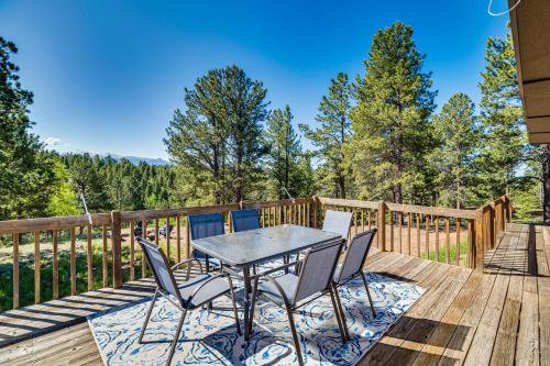 a patio with a table and chairs on a deck at Pike National Forest Access Secluded Divide Cabin in Divide