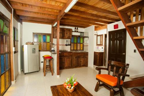 a kitchen with wooden ceilings and a table and a refrigerator at Chalets Suizos in Zapatoca