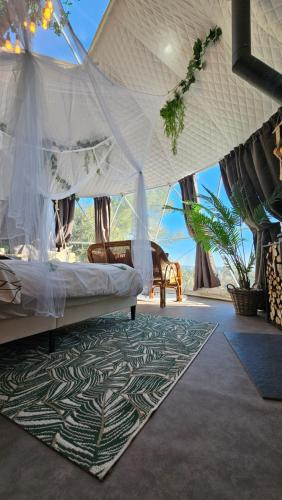 a bedroom with a bed in a tent with a rug at Logements insolites du Domaine de la Tuilière in Carnoules