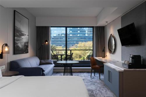 a hotel room with a bed and a living room at Radisson Hotel Cape Town Foreshore in Cape Town