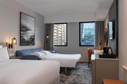 a hotel room with two beds and a couch at Radisson Hotel Cape Town Foreshore in Cape Town