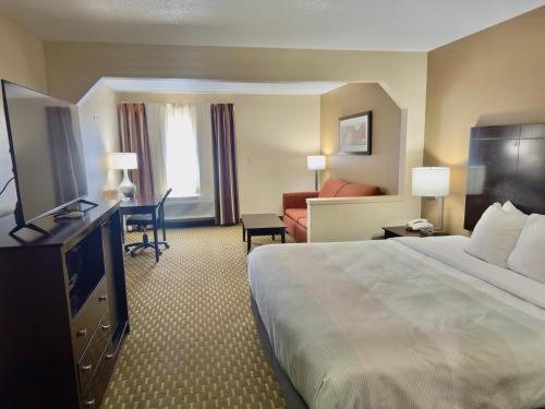 a hotel room with a bed and a television at Quality Inn & Suites Pine Bluff in Pine Bluff