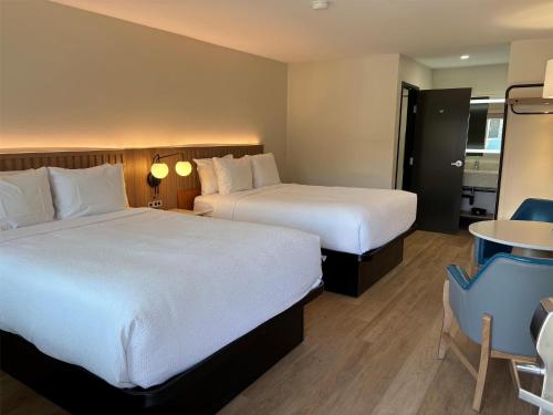 a hotel room with two beds and a table at Best Western San Diego Pacific Beach/Mission Bay in San Diego