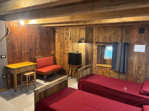 ein Zimmer mit zwei Betten und einem Schreibtisch und einem Stuhl in der Unterkunft riverside room Jean in Pontboset