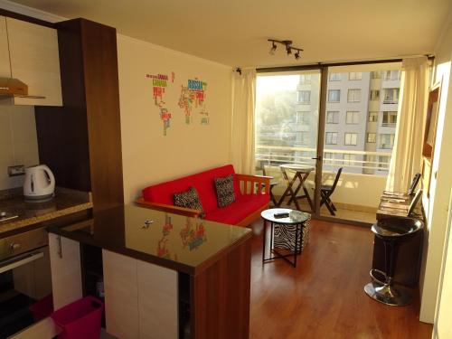 eine Küche und ein Wohnzimmer mit einem roten Sofa in der Unterkunft Geopark Valparaíso in Valparaíso